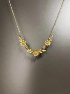 Goldfarbene Halskette mit Blumen- und Blättermotiv